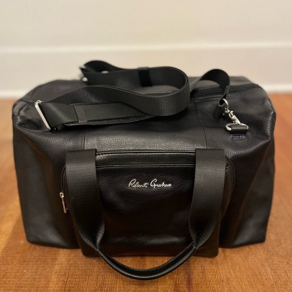 100% black genuine leather duffle/weekender bag. Boxy silhouette design.  Unisex